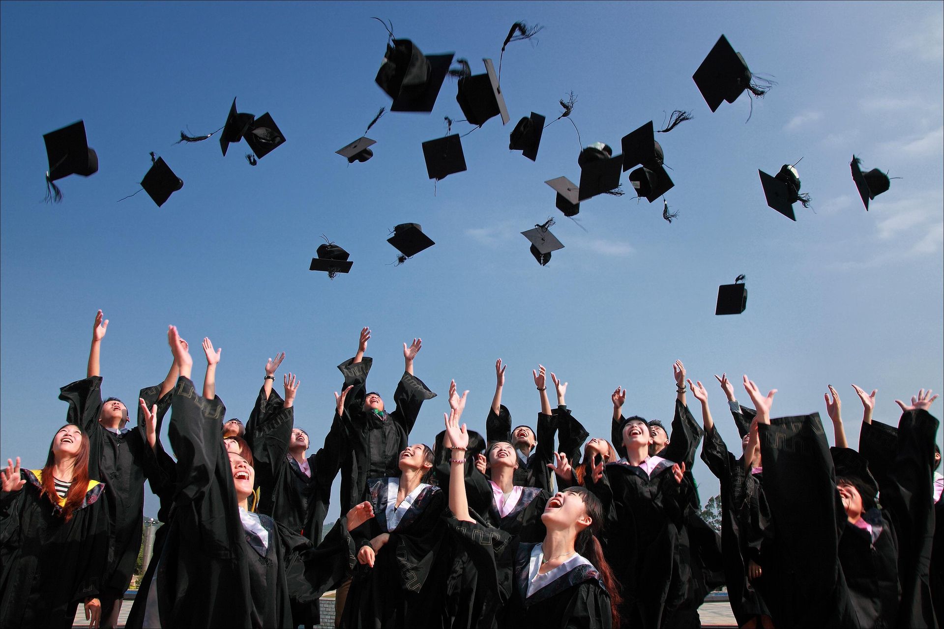 Graduates celebrating, throwing their caps in the air