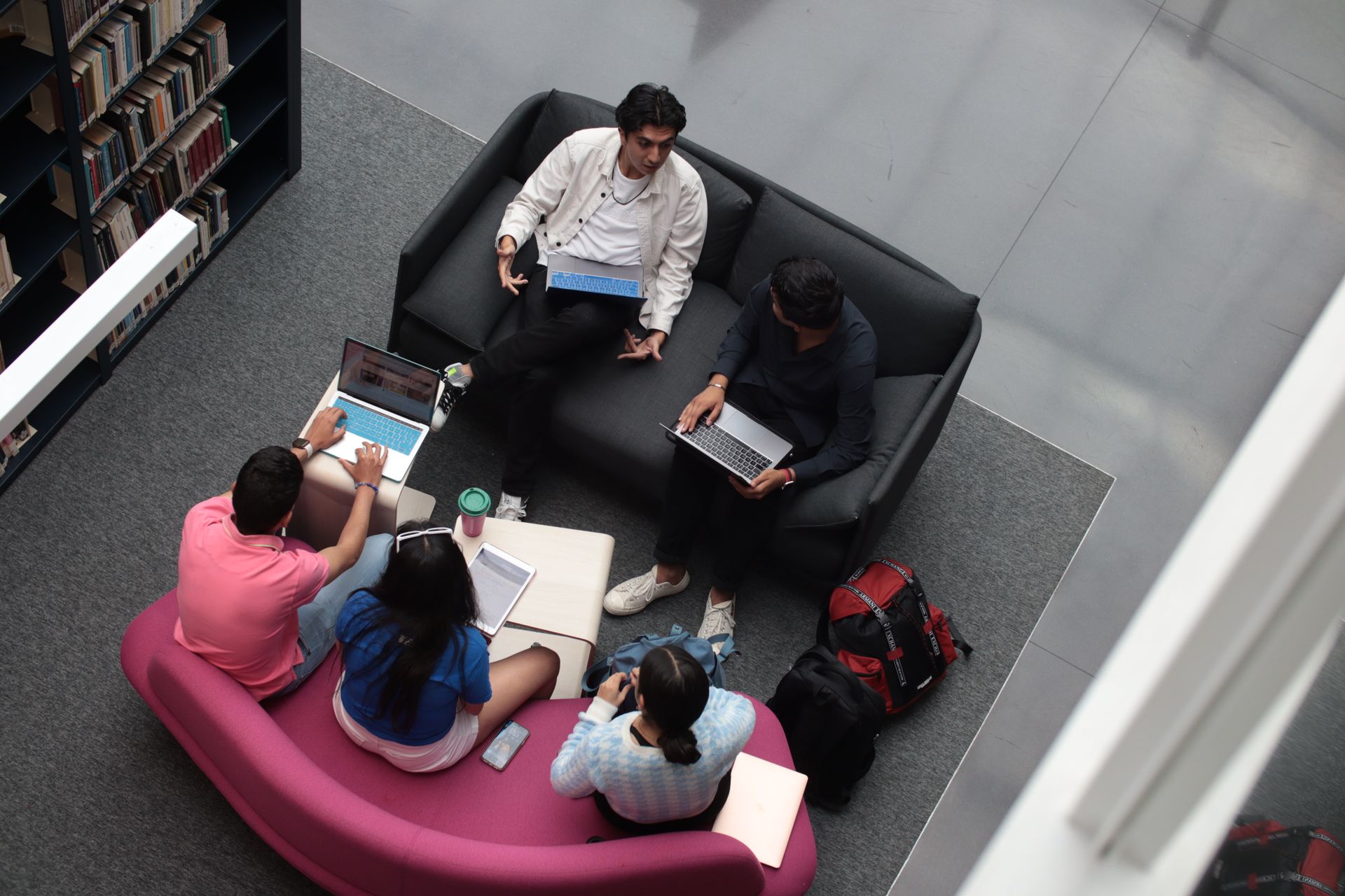 Students collaborating together with laptops in a university library